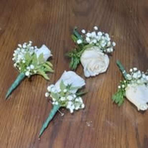 White rose boutonnieres with baby's breath and teal wraps