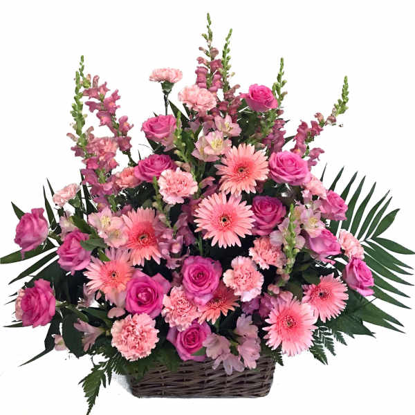 Pink roses, gerbera daisies, and carnations in a wicker basket