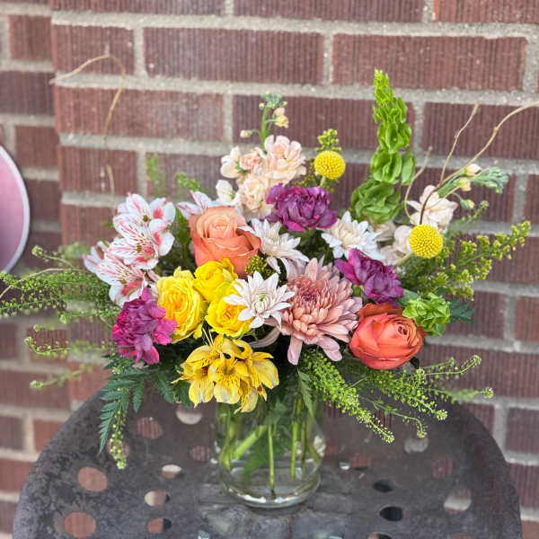 Mixed bouquet in a clear glass vase with roses, chrysanthemums, and alstroemeria