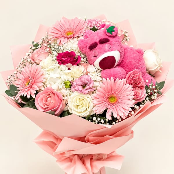 Pink bouquet with roses, gerbera daisies, and a plush teddy bear
