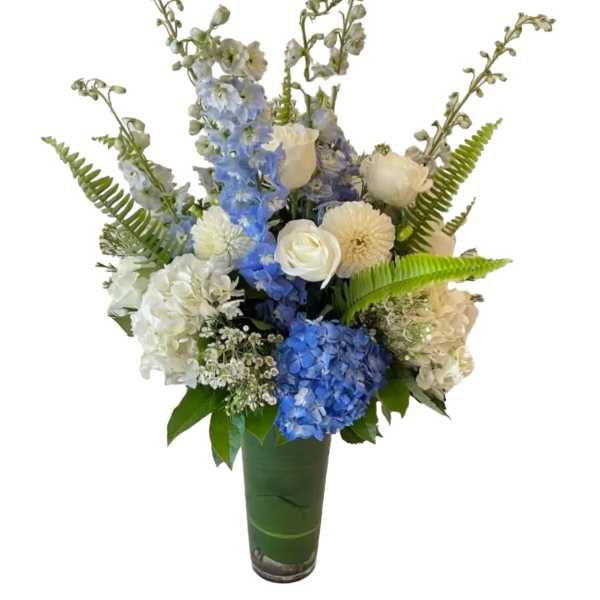 Blue and white floral arrangement in a tall green vase