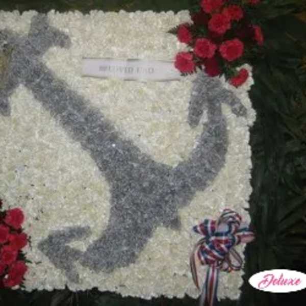 White floral funeral tribute with a gray dove design and red rose clusters