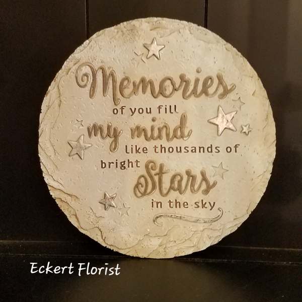 Round decorative sign with a star quote on a dark shelf