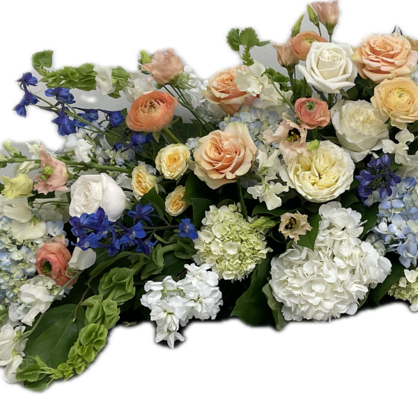 Large floral spray with roses, hydrangeas, and blue flowers