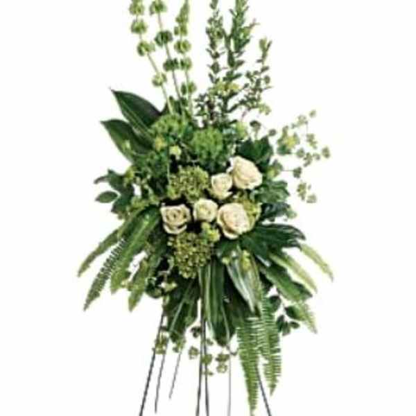 Tall white rose funeral spray on a metal easel