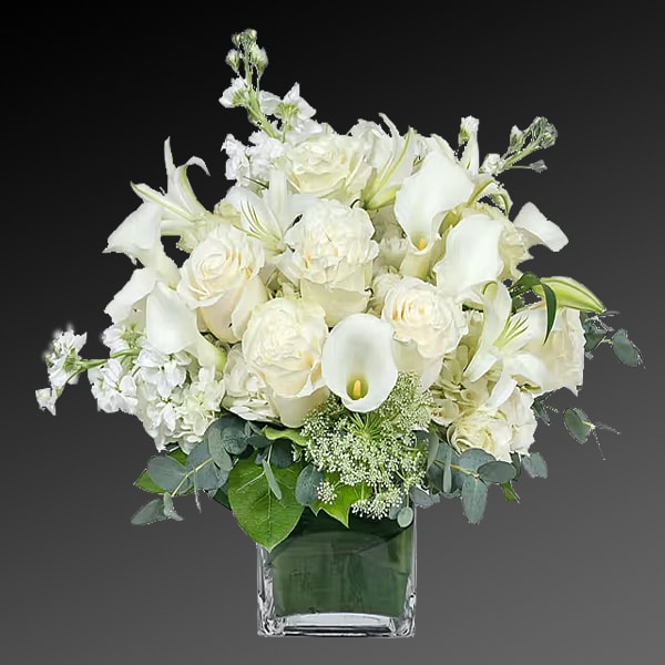 White floral arrangement in a square glass vase