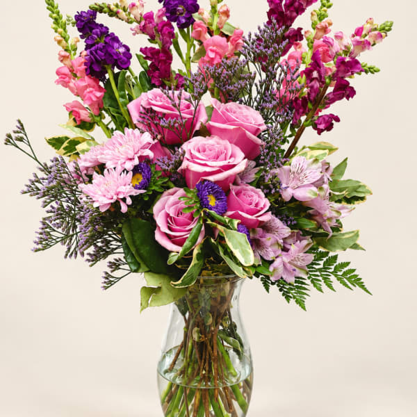 Pink and purple mixed bouquet in a clear glass vase