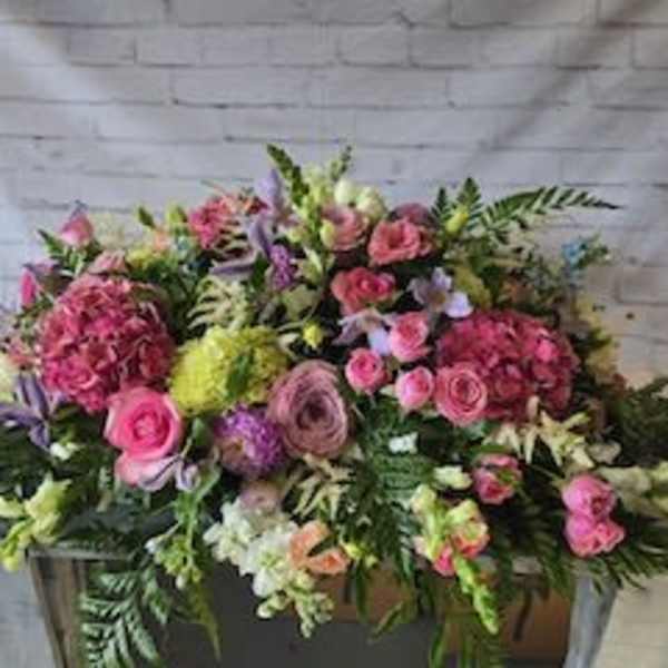 Large pink and purple floral arrangement in a container