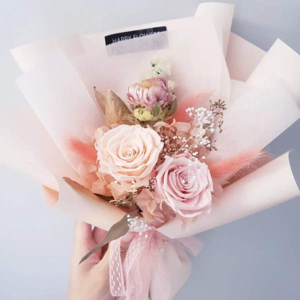 Pink and cream rose bouquet wrapped in pale paper