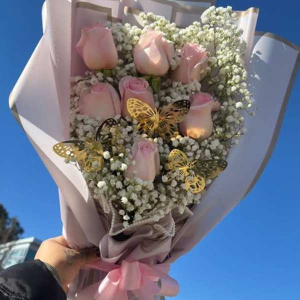 Bouquet of pale pink roses with white baby's breath and butterfly accents