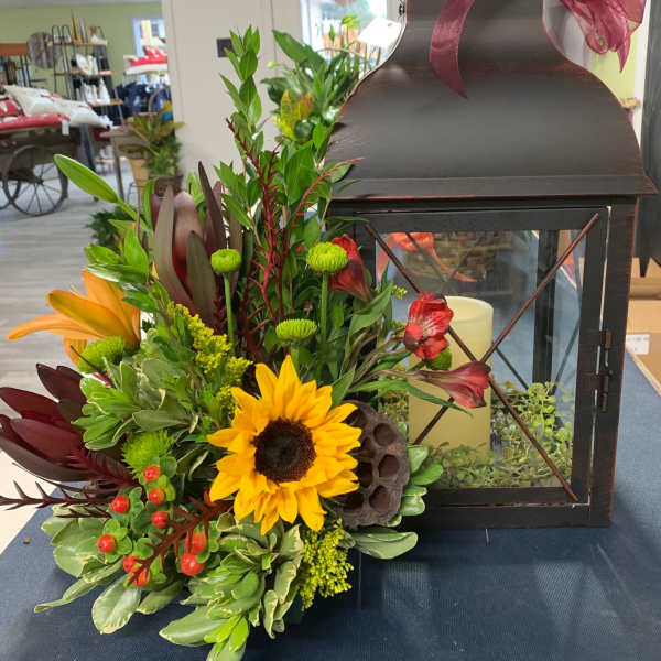Lantern with a colorful floral arrangement and burgundy ribbon