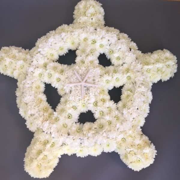 White floral arrangement shaped like a starfish on a dark background