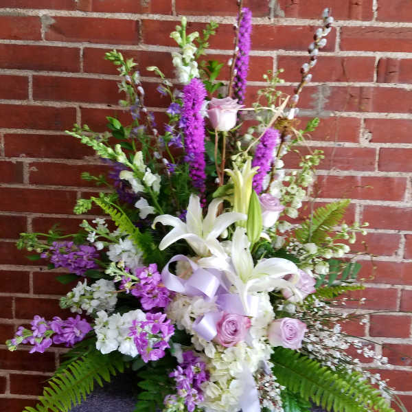 Tall floral arrangement with white lilies and lavender roses