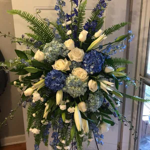 Tall blue and white floral standing spray on an easel