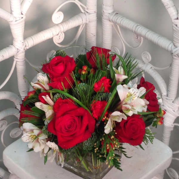 Red roses and white alstroemeria arranged in a square glass vase