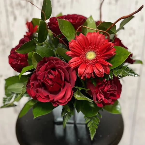 Red rose bouquet with a red gerbera daisy and green foliage