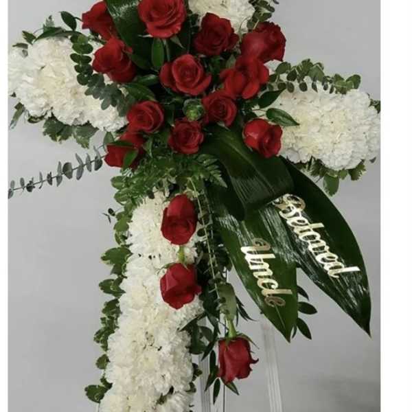Standing floral spray with red roses and white blooms on a white easel