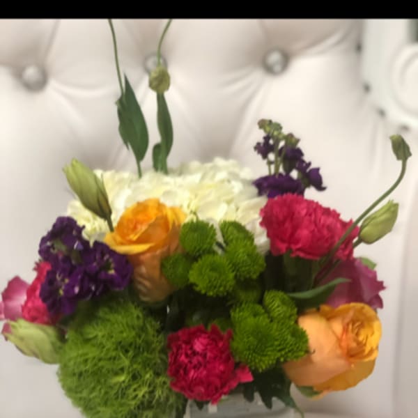 Colorful mixed bouquet in a white square vase