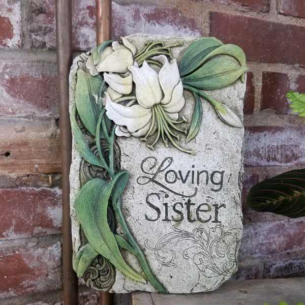 Decorative stone plaque with white lilies and the words Loving Sister