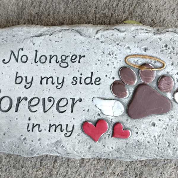 Memorial stone with a paw print, wings, and the words "Forever in my side"
