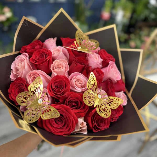 Bouquet of red and pink roses with gold butterfly decorations