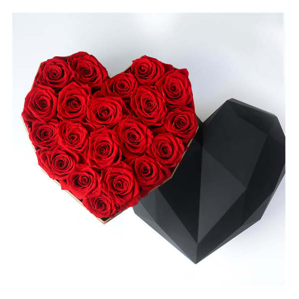 Heart-shaped box filled with red roses beside a black faceted heart box