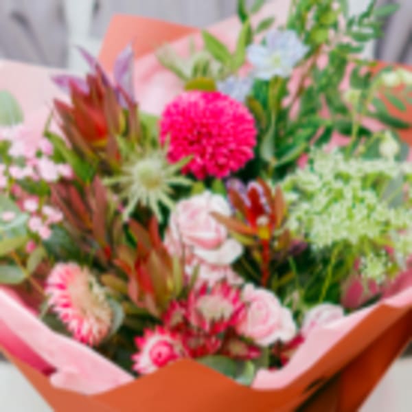 Mixed bouquet with pink and green flowers wrapped in pink paper