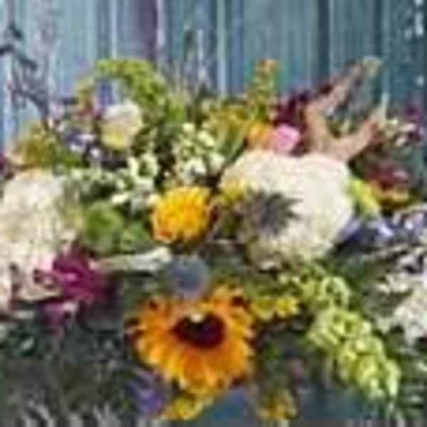 Mixed bouquet with sunflowers and white blooms in a container
