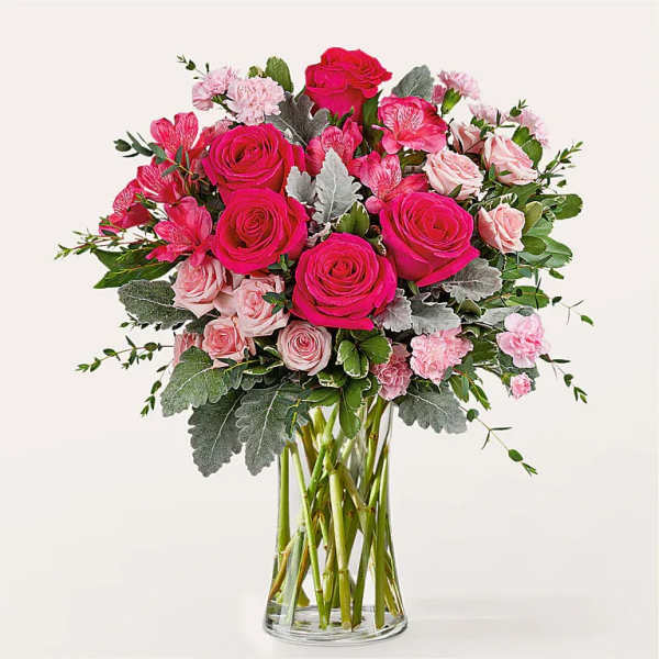 Pink roses and carnations in a clear glass vase