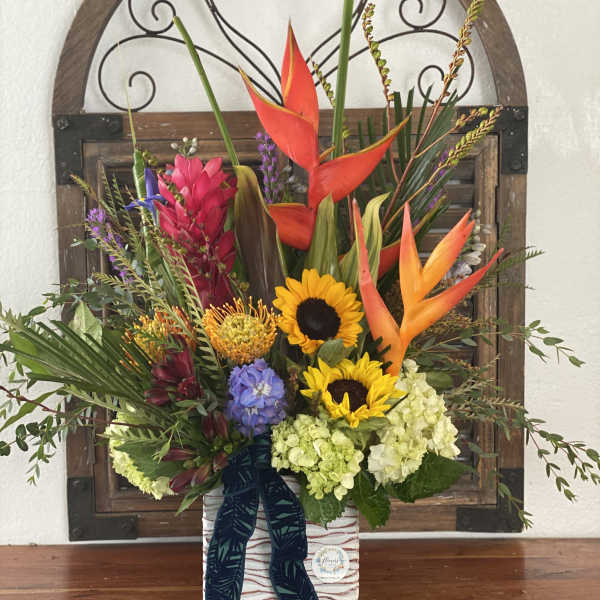 Tropical floral arrangement with sunflowers and orange heliconia in a decorative box