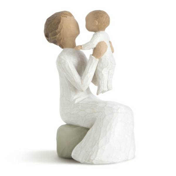 Two white figurines of a seated woman holding a child