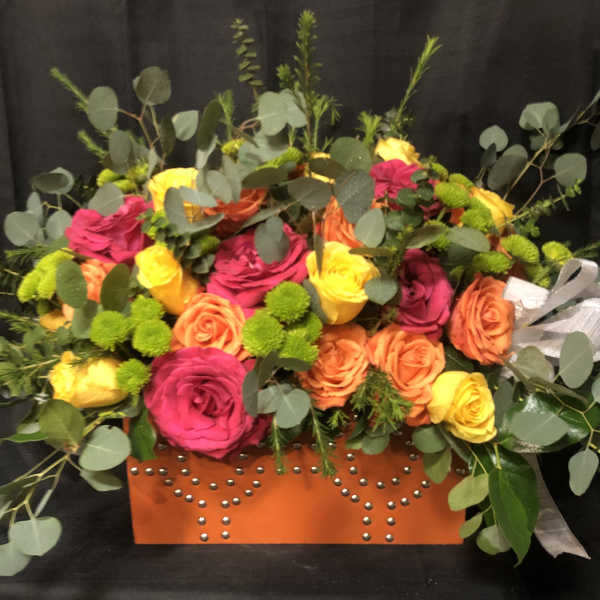 Bright mixed rose arrangement in an orange studded box