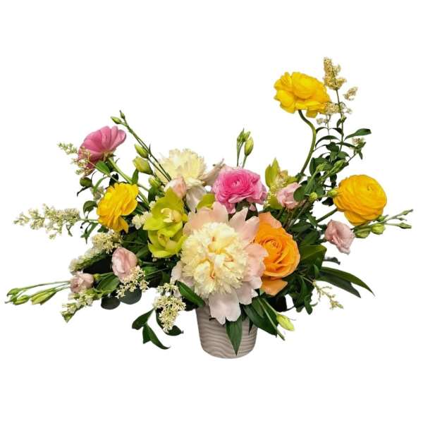 Mixed bouquet of yellow, pink, and peach flowers in a ceramic vase