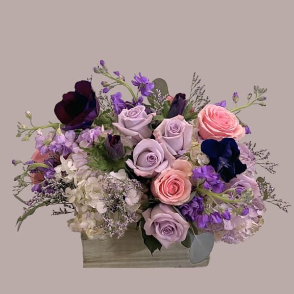 Lavender and pink roses arranged in a rectangular wooden box