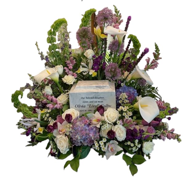 Large sympathy floral arrangement with white calla lilies and roses around an urn
