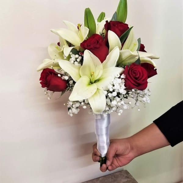 Handheld bouquet of red roses and white lilies with baby's breath