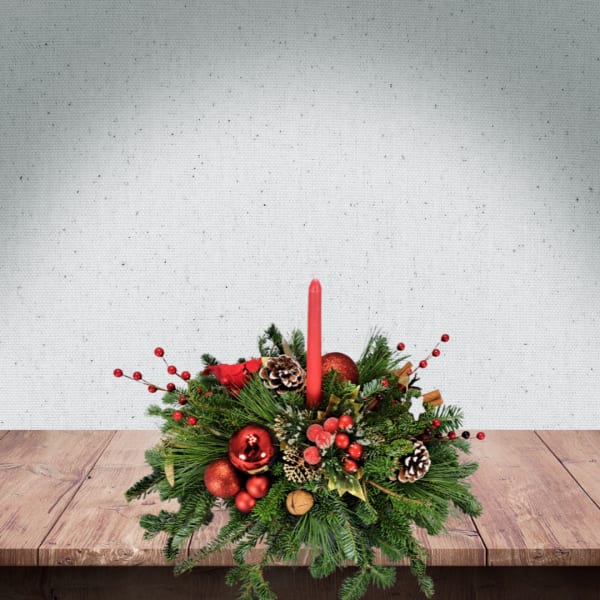 Christmas centerpiece with red candle, pinecones, and red ornaments
