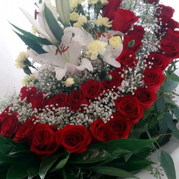 Red roses and white lilies arranged with baby's breath