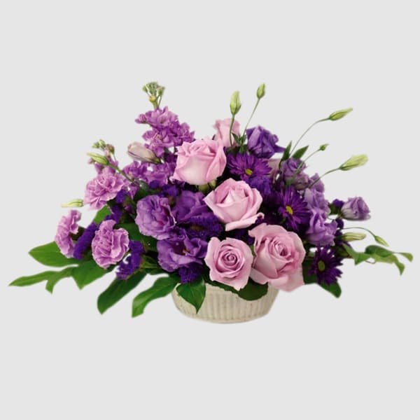 Pink and purple roses arranged in a low basket