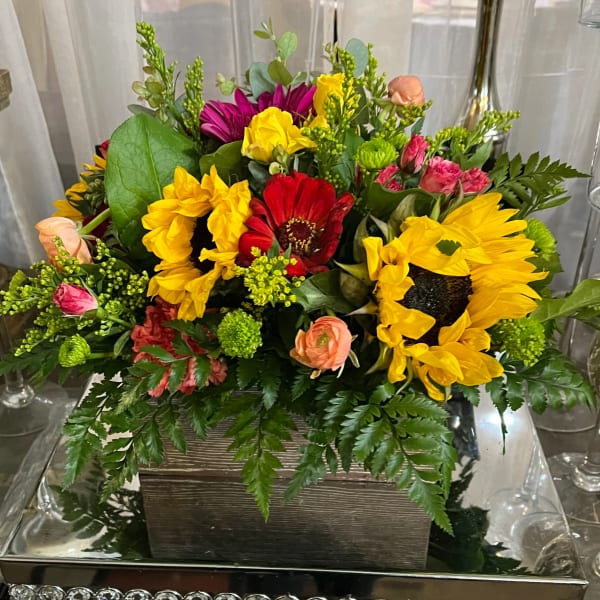 Mixed bouquet with sunflowers, red gerbera daisies, and pink roses in a wooden box