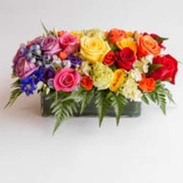 Colorful mixed rose arrangement in a rectangular container