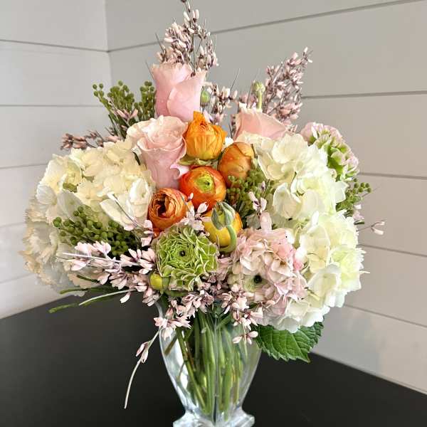 Mixed bouquet of pastel flowers in a clear glass vase