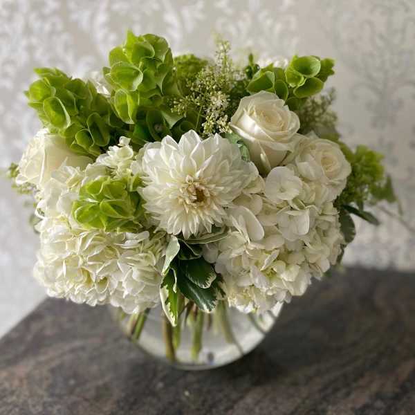White and green bouquet in a clear glass vase
