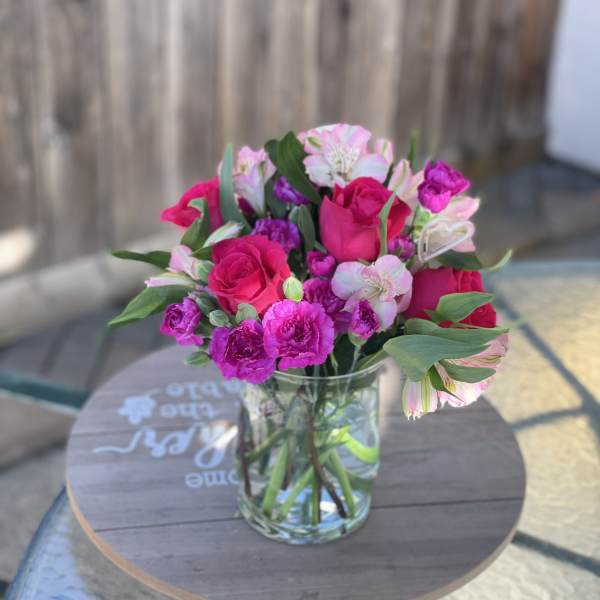 Pink and white bouquet of roses and alstroemeria in a clear glass vase