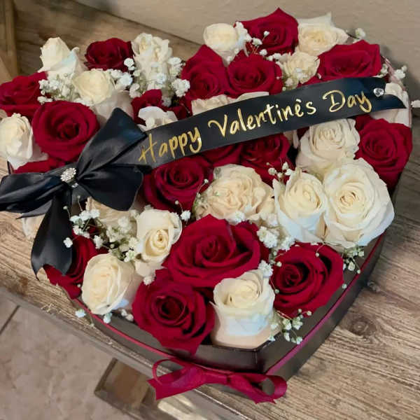 Heart-shaped arrangement of 36 roses, red and white roses, with baby's breath.