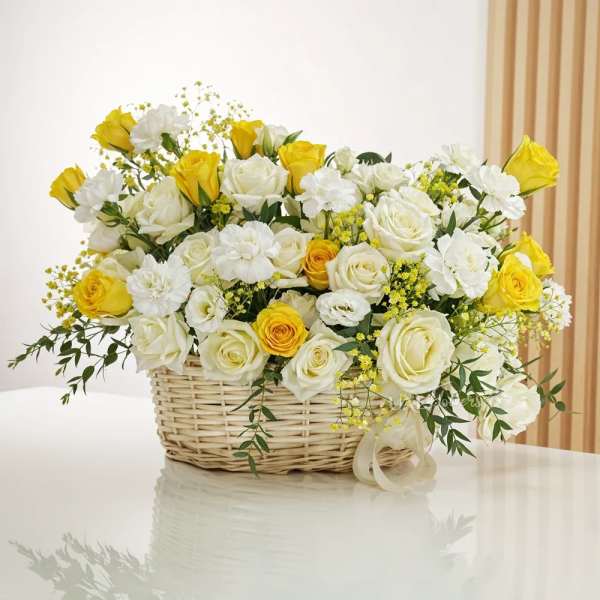Yellow and white roses arranged in a wicker basket