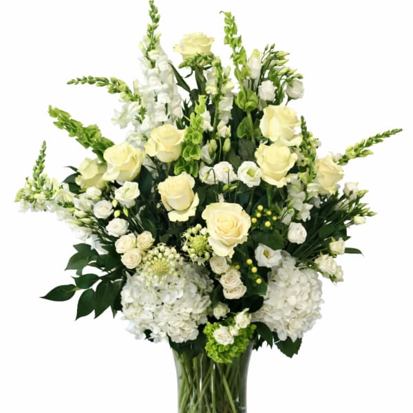 White and pale yellow floral arrangement in a glass vase