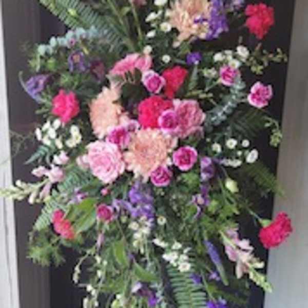 Tall standing floral spray with pink, purple, and white blooms