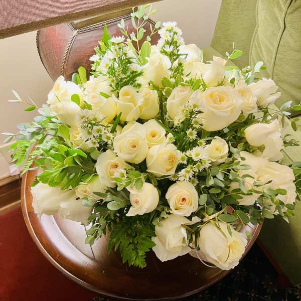 Bouquet of white roses with small white filler flowers and greenery
