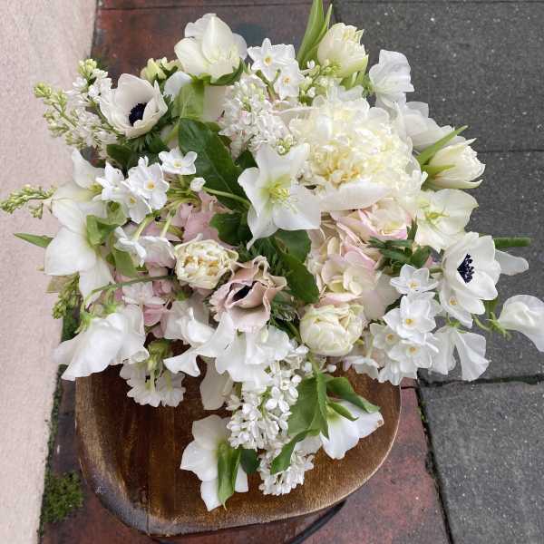White and pale pink mixed bouquet in a wooden bowl